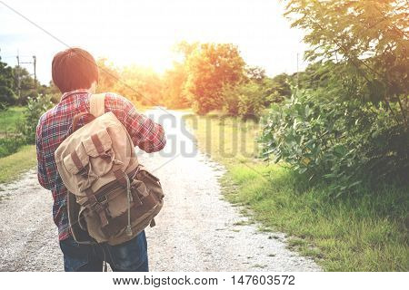 Back portrait of Young man traveler with backpack travel concept vintage tone