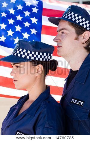 dva policejní důstojník stál před americkou vlajkou