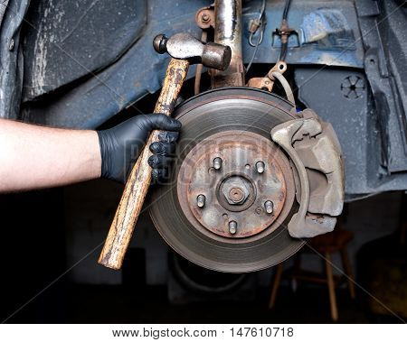 Front disc brake caliper, bracket, rotor of a car after accident on hydraulic lift