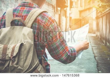 young tourist with a beard holding a map choose where to travel
