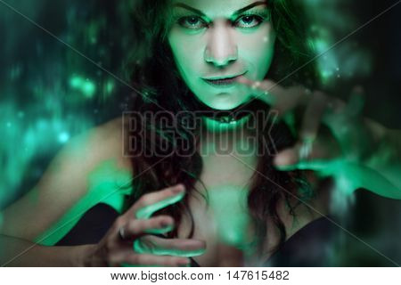 Halloween. Witch creates magic. Beautiful and sexy woman with a mystical light