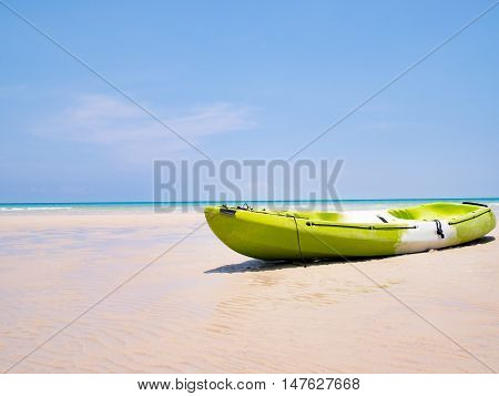 Green Kayak boat on the tropical beach background and clear blue sky at sea. Happy summer holiday concept