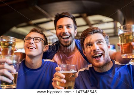 sport, people, leisure, friendship and entertainment concept - happy football fans or male friends drinking beer and celebrating victory at bar or pub