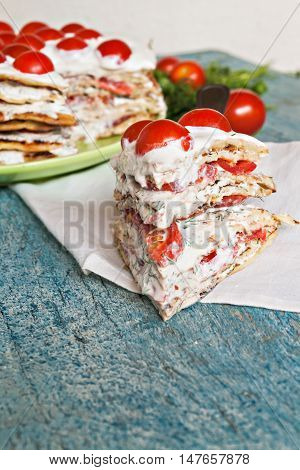 zucchini cake with tomato and parsley on a blue wooden background