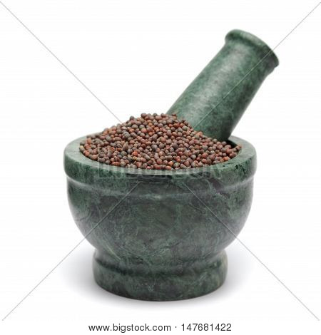 Organic Brown Mustard (Brassica juncea) on marble pestle. Isolated on white background.
