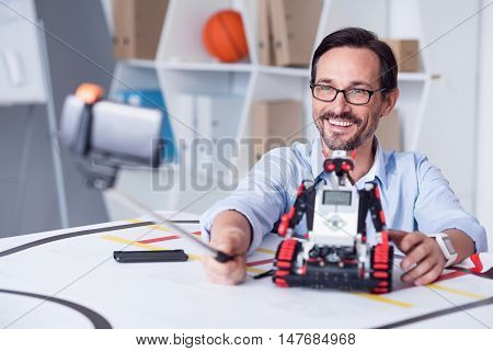 What a moment Happy man in his forties taking pictures with a droid