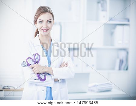 Portrait of happy successful young female doctor holding a stet