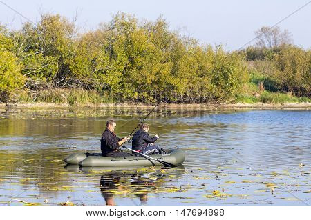 The river Chaus Kolyvan district Novosibirsk oblast, Siberia, Russia - September 17, 2016: fishermen in an inflatable rowing boat with a spinning rod looking for a predatory fish on the river.