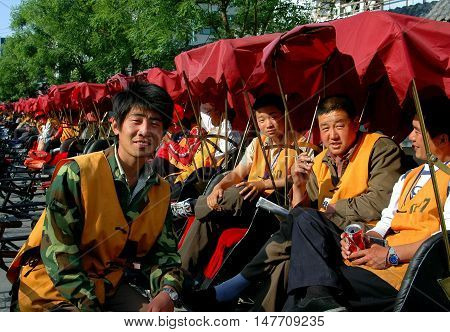 Beijing China - May 5 2005: Pedicab drivers sitting in their bicycle taxis waiting for fares at the Shi Sa Hai Hutong