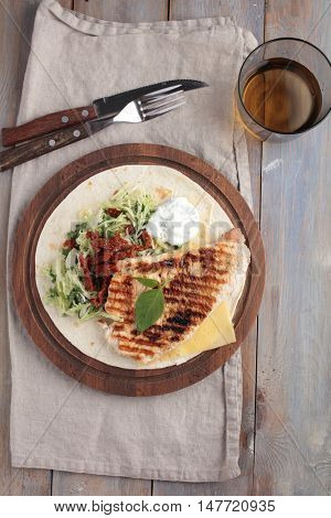 Grilled chicken meat, vegetables, cheese, and tzatziki on pita bread