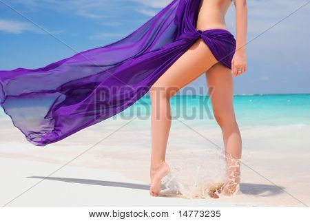 Kvinde med sarong på caribisk strand
