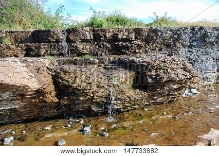 Limestone rocks with flowing water at the swedish island Oland in the Baltic Sea