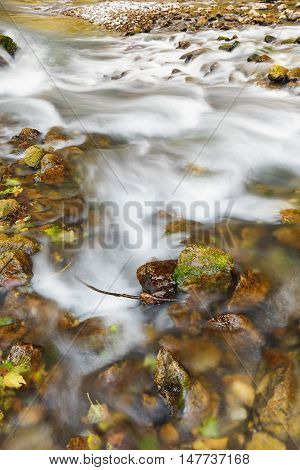 River flowing through rocks with white water rapids in long exposure, close up