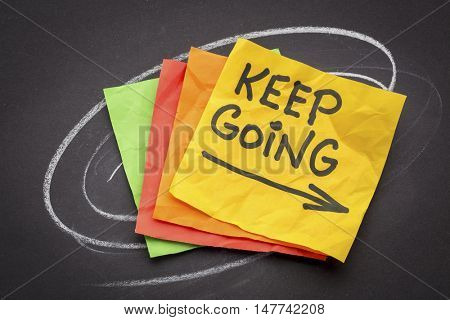 keep going - motivation or determination concept - handwriting on colorful sticky notes against black paper