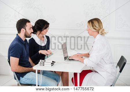 Doctor and young couple patients at office.