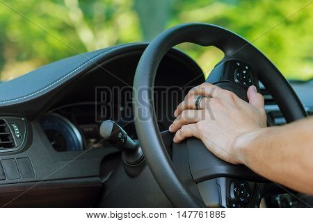 Man's hand on the steering wheel of a car wheel driver car