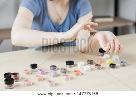 Make up artist testing eyeshadow colors. Woman stylist trying cosmetics color on her hand. Professional coloring, visagiste, beauty concept, swatches
