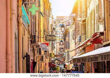 Cannes, France - June 14, 2016: Narrow street with shops and boutiques in Cannes city on the french riviera.