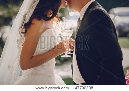 gorgeous wedding couple enjoys champagne sitting in the restaurant