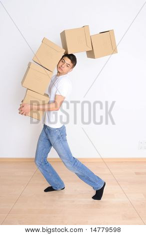 Joven llevando y dejando caer su pila de cajas de mudanza