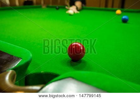 Men's hand hold Snooker cue with snooker ball on green table background