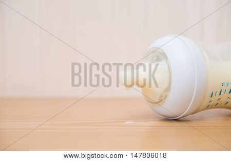 baby bottle and milk on a wood table close up