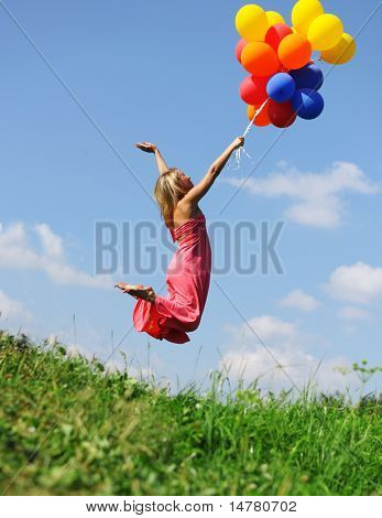 Ragazza che saltava con palloncini cercando di volare