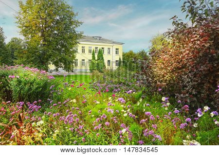beautiful summer garden landscape with flowers trees and building on the background