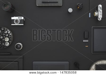 Work space on black table of a creative designer or photographer with laptop tablet camera and other objects of inspiration and copy space. Stylish home studio concept of technology trends.