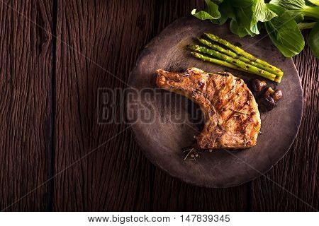 grilled pork chop with vegetable on wooden board