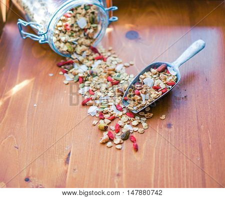 Healthy Homemade Granola in a Jar and Scoop with Nuts and Gogi Berries