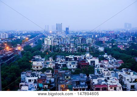 View of noida city at dawn from a skyscraper. Shows the many homes, apartments, traffic and newly constructed metro