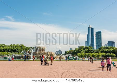 Chicago, USA - May 30, 2016: Buckingham Memorial Fountains in Grant Park in Illinois with people walking on a hot summer day with skycrapers.