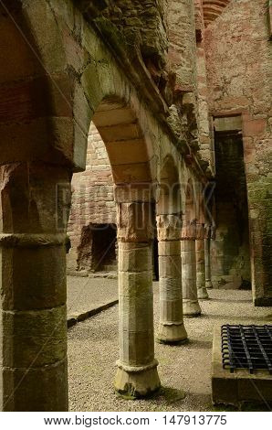 A view of the supporting columns and arches beneath the façade wall in Crichton castle