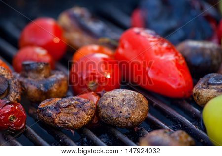 Red yellow bell peppers potatoes mushrooms tomatoes and eggplant grilled until golden brown. The concept of proper nutrition and a healthy lifestyle. Cooking vegetables on the barbecue.