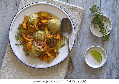 Bread dumplings with chanterelles on a plate with fresh Majoram
