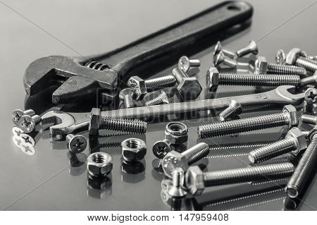Wrenches tool nuts and bolts monochrome on a glass floor background