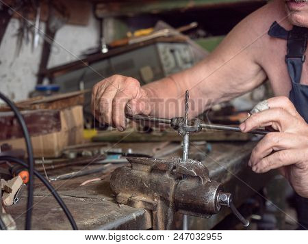Older Man In Harnees At Home Workshop. Close Up View On Process Of Screw Thread Turning. Worker Is S