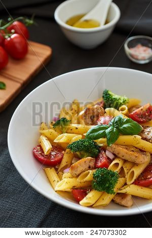 Italian Food. Fusilli Pasta Salad With Italian Dressing, Tomatoes, Broccoli And Basil Leaves On Blac