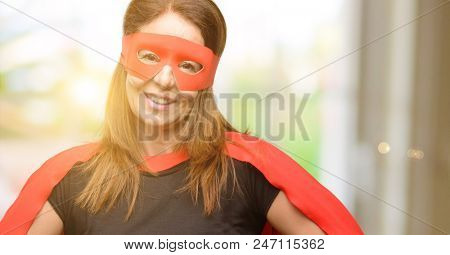 Middle age super hero woman wearing red mask and cape confident and happy with a big natural smile laughing