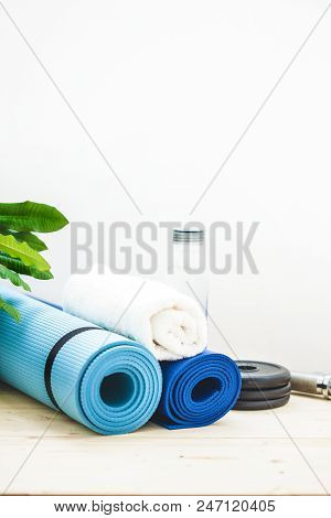 Set For Sports, A Yoga Mat, A Towel, A Dumbbell And A Bottle Of Water On A Light Background. The Con