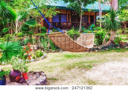Tropical Beach. A Hammock Between Two Palm Trees On The Beach. Concept Of Rest. Beautiful Beach.