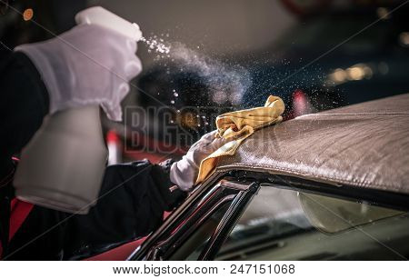 Men Spraying Vinyl Protectant For The Convertible Car Soft Roof.