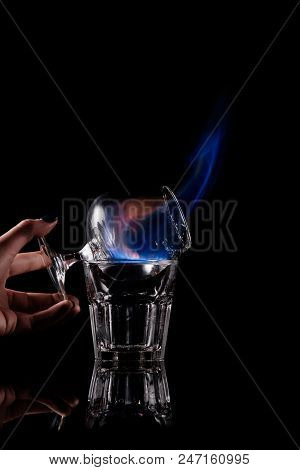 Partial View Of Woman Holding Glass With Burning Sambuca Alcohol Drink On Black Background