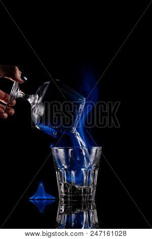 Partial View Of Woman Pouring Burning Sambuca Alcohol Drink Into Glass On Black Background