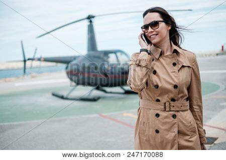 Business woman near private helicopter