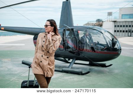 Business woman near private helicopter