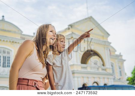 Mom And Son On Background Of Old Town Hall In George Town In Penang, Malaysia. The Foundation Stone 
