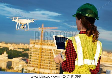 Drone inspection. Operator inspecting construction building site flying with drone