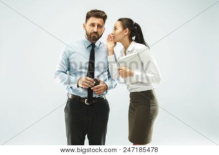 Secret, Gossip Concept. Young Woman Whispering A Secret Behind Her Hand To Boss. Business Woman Isol